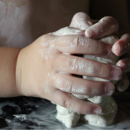 Mains d'enfant dans de l'argile blanche